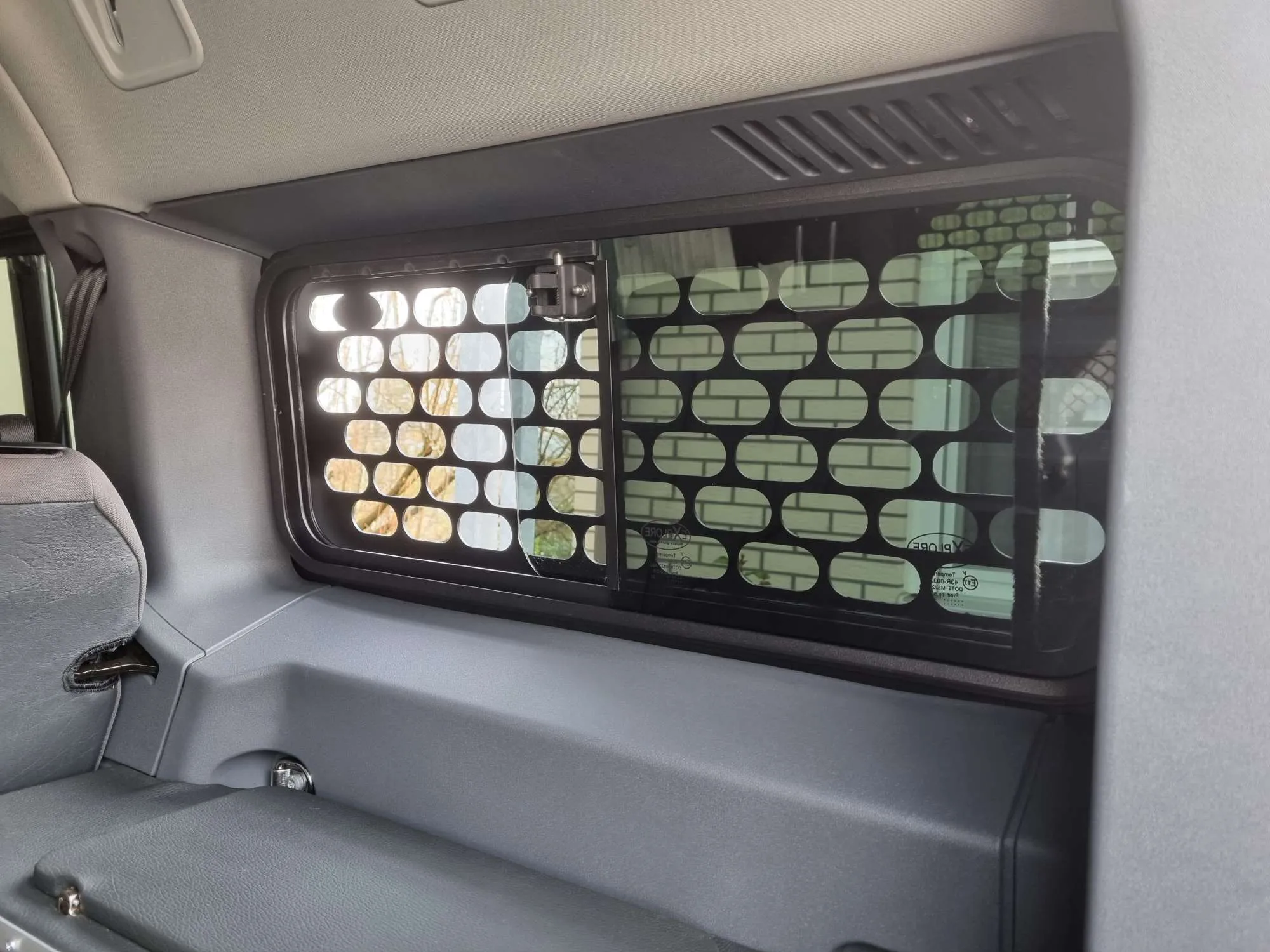 Interior view of INEOS Grenadier with window guard mounted on side window, cabin visible