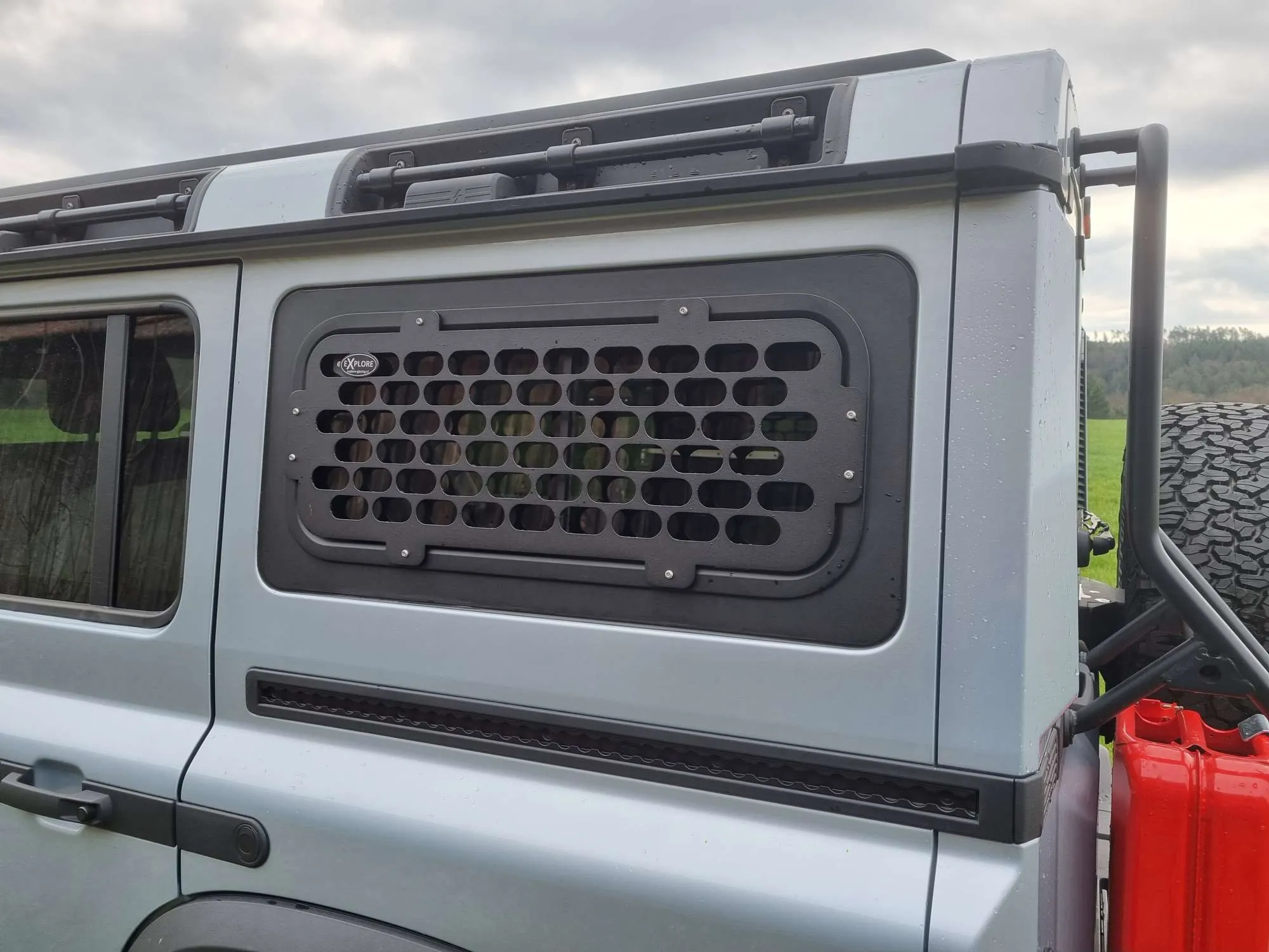 INEOS Grenadier with black perforated exterior window guard, parked in outdoor setting