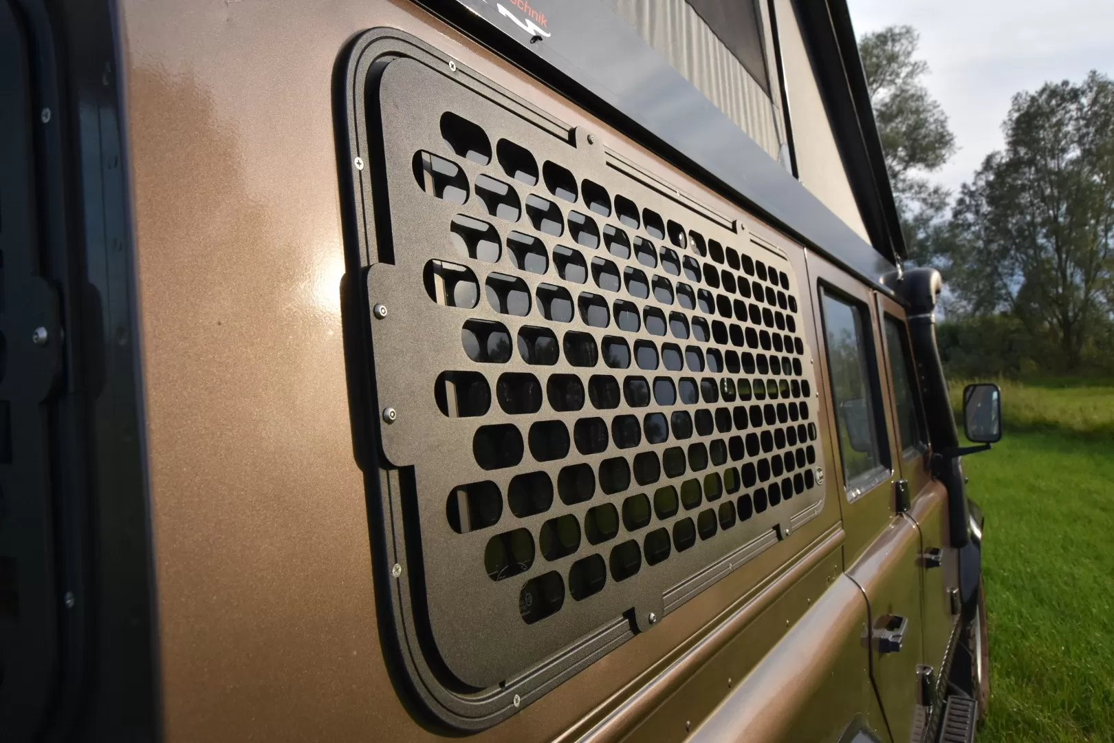 Explore Glazing Land Rover Defender sliding window with a window guard.