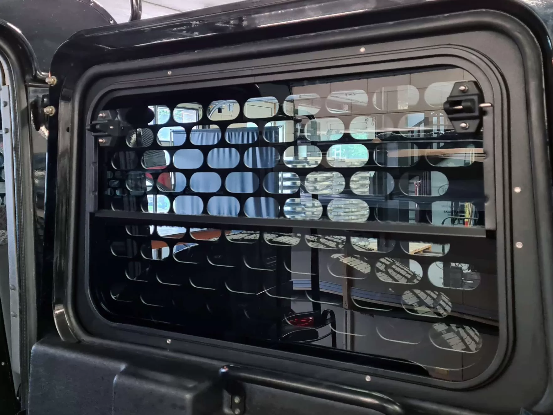 Explore Glazing Land Rover Defender tail door halfdrop window with an external window guard inside view